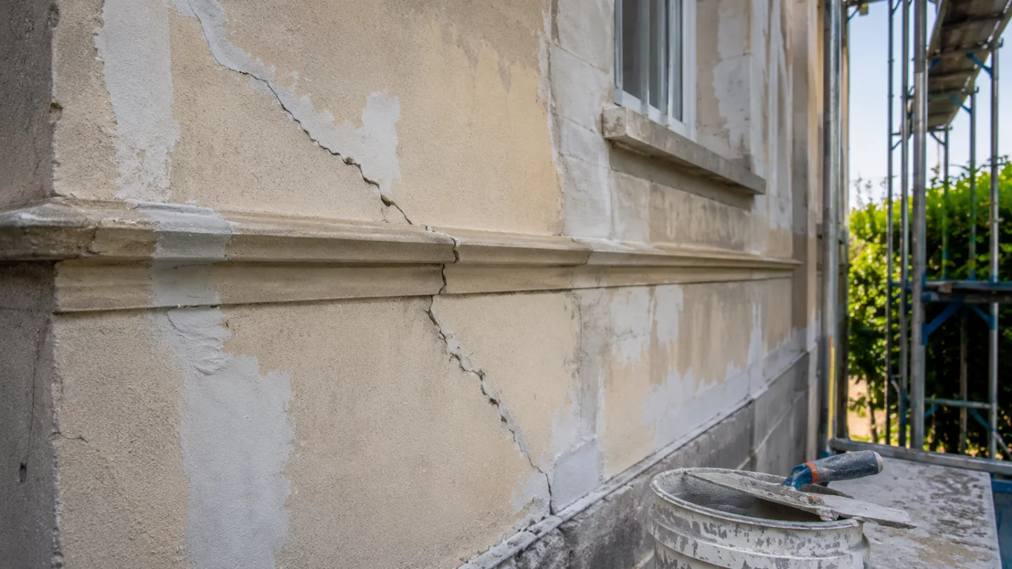 Image générée : Réparations en cours sur façade en stuc