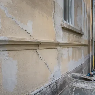 Image générée : Réparations en cours sur façade en stuc